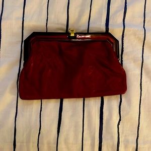 It is a dark maroon genuine leather clutch bag. Made in Italy